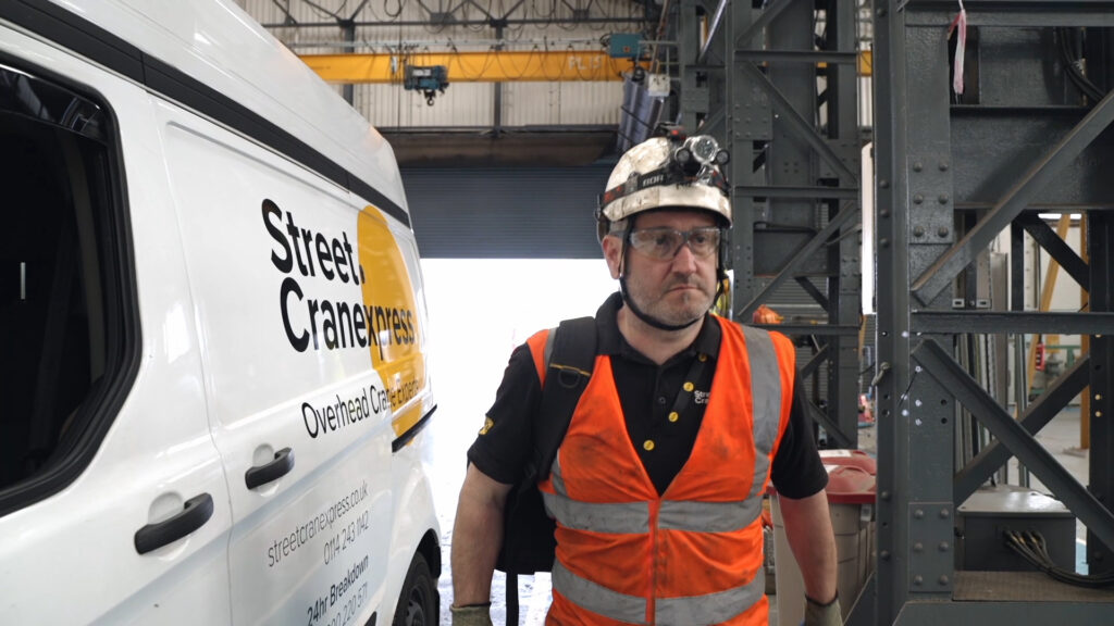 A man standing next to a street cranexpress van
