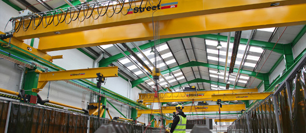 A variety of yellow overhead cranes installed in a warehouse