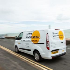 A white van with text that says Street Cranexpress, driving on the road