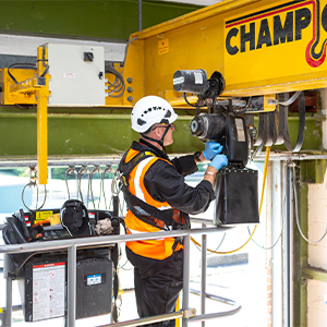 A man in a hard hat working on a crane hoist