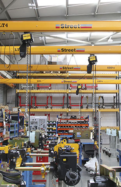five light cranes with chain hoists in a warehouse