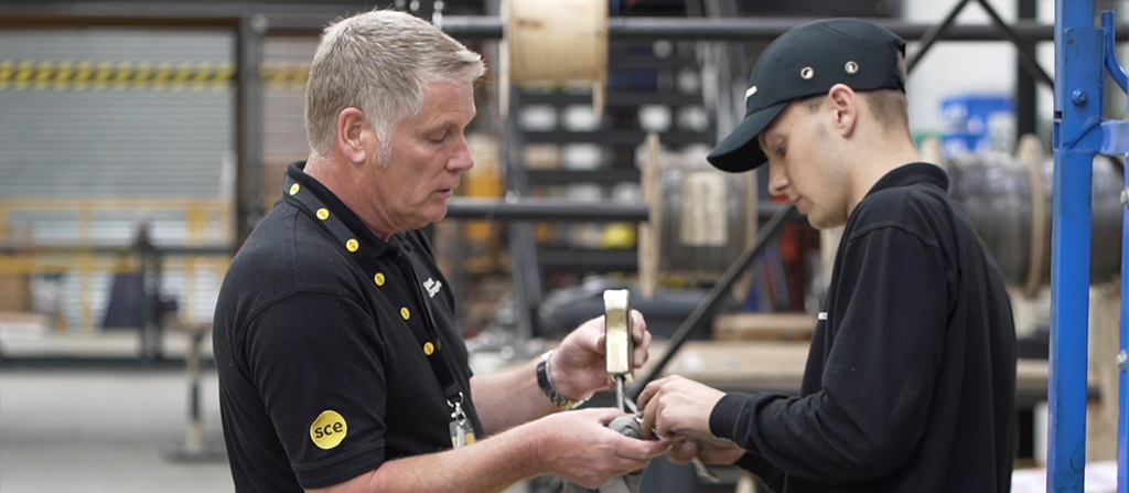 Two men stood opposite each measuring something