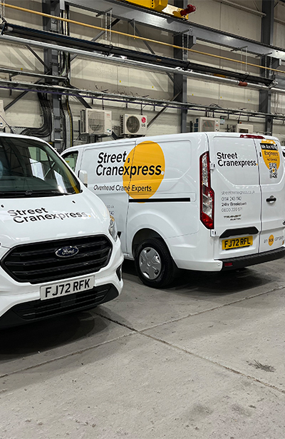 two white vans parked in a warehouse with street Cranexpress in black text