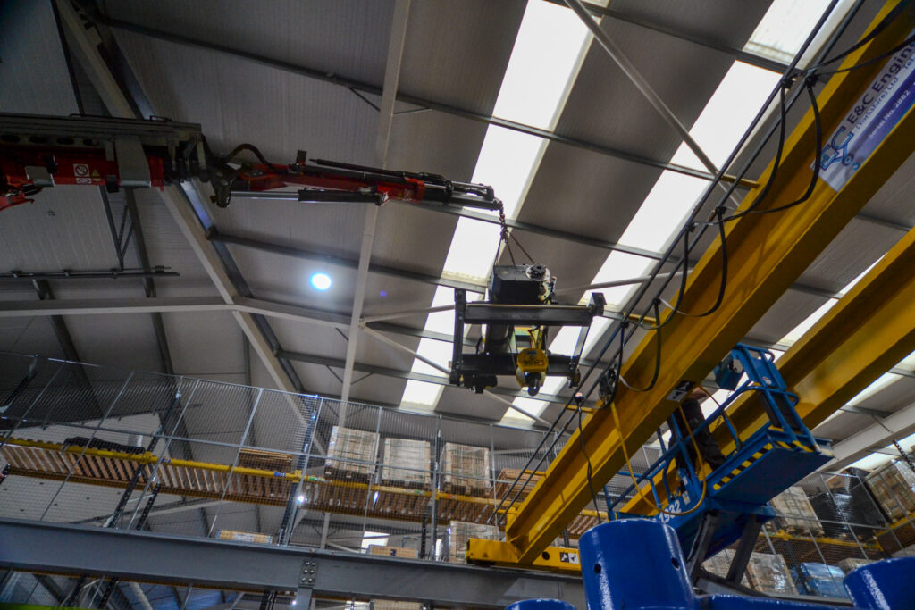 A mobile crane installing the new hoist onto an existing overhead crane