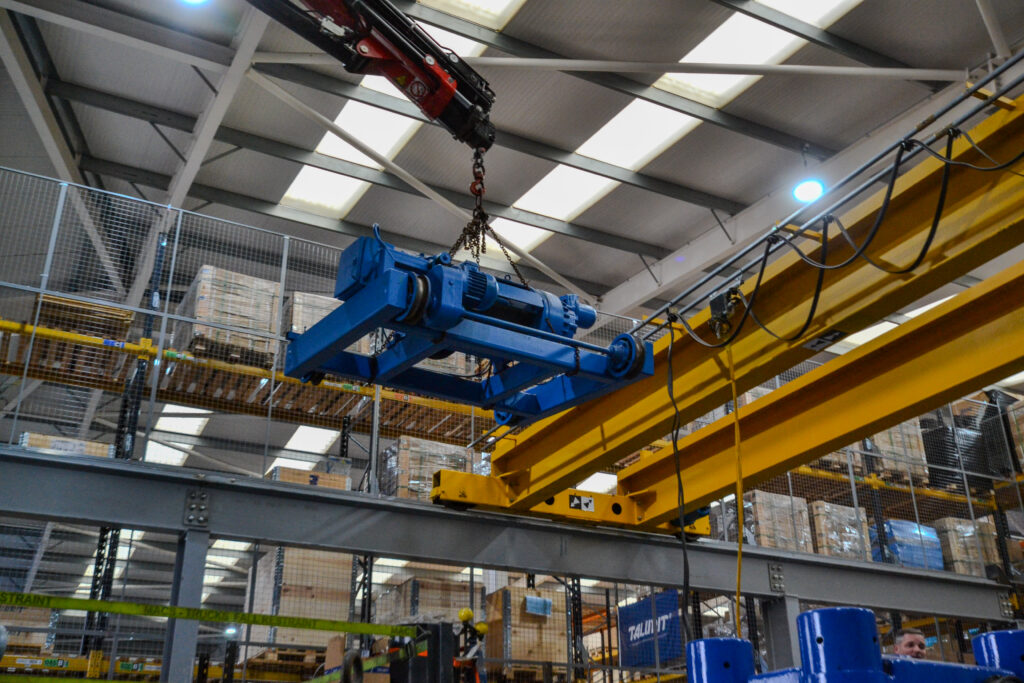 A mobile crane removing an old hoist from an existing overhead crane